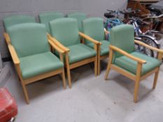 A set of seven wood framed low back armchairs upholstered in a green fabric together with a further