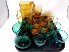 Two 20th century amber glass jugs with set of six beakers together with a further green glass jug