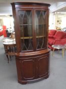 A double door corner display cabinet fitted cupboards beneath