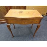 An Edwardian oak serpentine fronted cutlery table