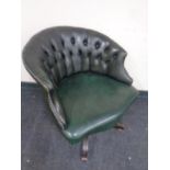 A green buttoned leather swivel desk chair