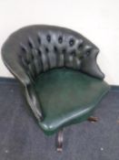 A green buttoned leather swivel desk chair