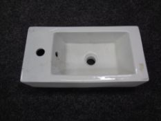 A ceramic wall mounted hand sink, width 25 cm.