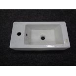 A ceramic wall mounted hand sink, width 25 cm.