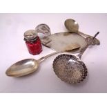 A small silver topped ruby glass jar together with three pieces of silver cutlery and a further