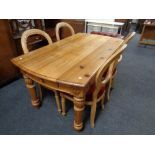 A carved pine dining table together with a set of four balloon back dining chairs