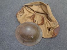 A WWII tin helmet together with a canvas bag