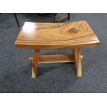 A contemporary hard wood curved stool