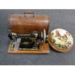 A vintage Singer hand sewing machine in oak case together with a tapestry upholstered foot stool
