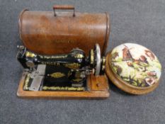 A vintage Singer hand sewing machine in oak case together with a tapestry upholstered foot stool