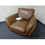 A Natuzzi brown leather armchair together with a leather care kit
