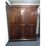 A contemporary mahogany effect triple door wardrobe