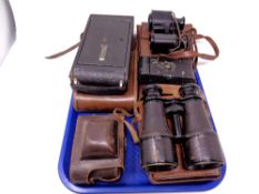 A tray containing antique Kodak boxed camera and further cameras and two pairs of antique field