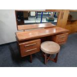 A 20th century teak G plan knee hole dressing table fitted four drawers with circular stool