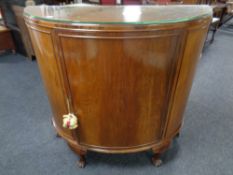 A walnut bow fronted cabinet on claw and ball feet