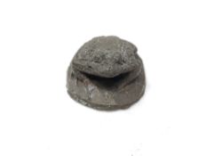 A bronze miniature figure of a toad, approximately 35 mm in diameter.