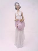 A Lladro figure of a woman in white dress holding a summer hat
