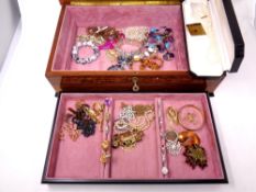 A high gloss jewelry box containing a box of costume jewelry including dress rings,