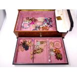 A high gloss jewelry box containing a box of costume jewelry including dress rings,