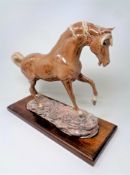 A Heredities pottery figure of a horse on wooden plinth