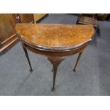 A 20th century walnut demi-lune turnover top card table