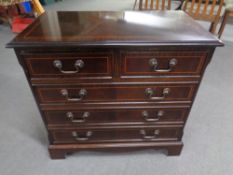 A reproduction mahogany effect five drawer chest