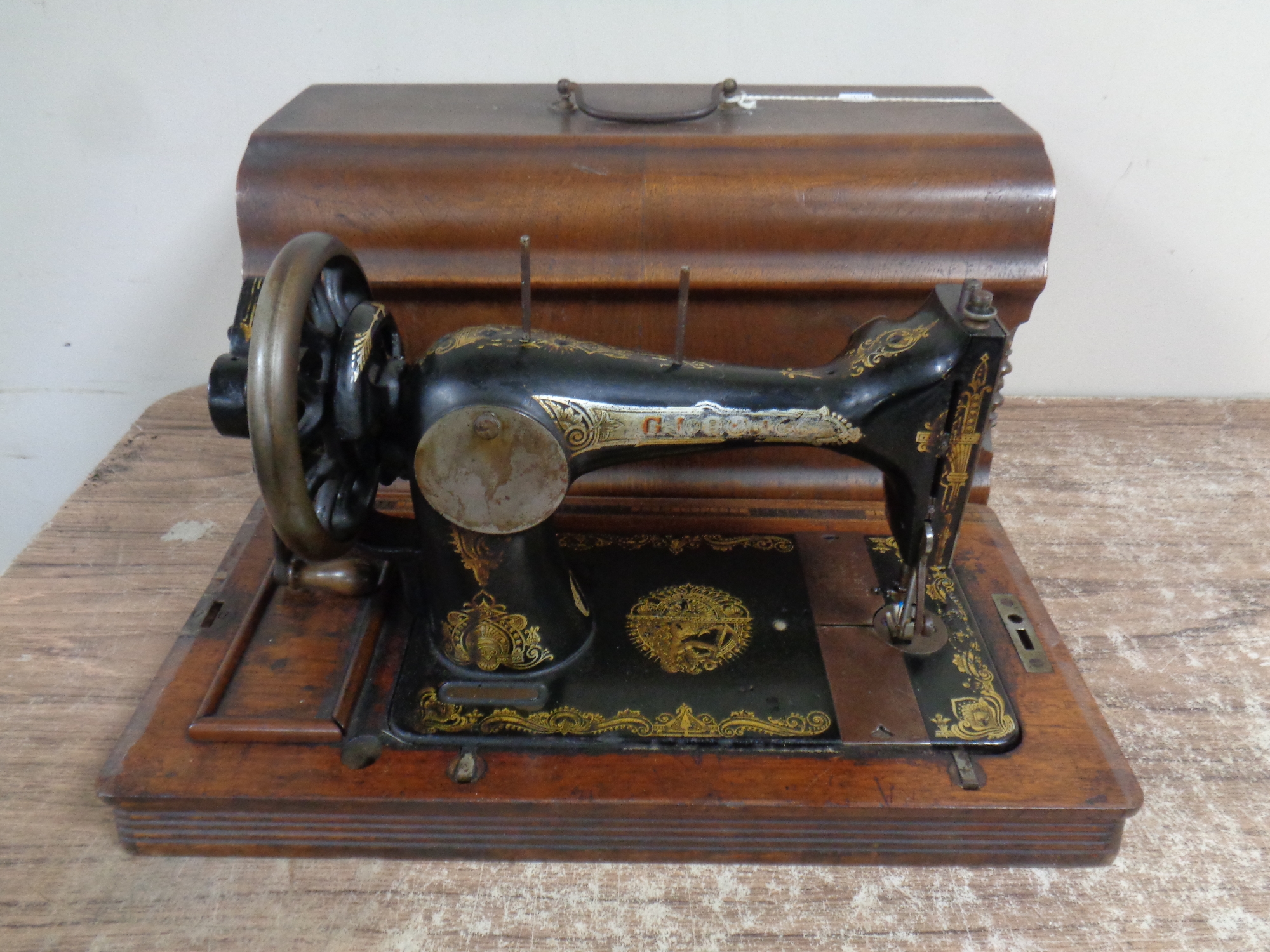 A vintage Gloria hand sewing machine in case