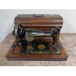 A vintage Gloria hand sewing machine in case