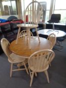 A circular contemporary extending kitchen table together with five chairs