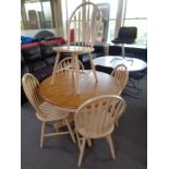 A circular contemporary extending kitchen table together with five chairs