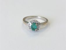 An 18ct white gold emerald and diamond cluster ring, size N CONDITION REPORT: 3.