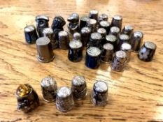A collection of thirty-four thimbles, including at least five silver examples,