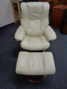A Stressless cream leather swivel adjustable armchair with stool