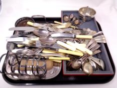 A tray containing a quantity of plated wares including loose cutlery, toast rack, serving tray,