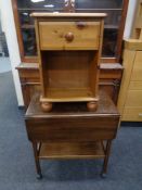 A mid 20th century flap sided two tier tea trolley together with a pine swivel adjustable armchair