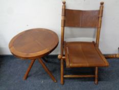 A folding fruit wood and leather campaign style chair together with matching circular occasional