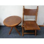 A folding fruit wood and leather campaign style chair together with matching circular occasional