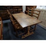 An oak refectory dining table together with a set of four rush seated ladder back dining chairs