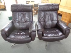 A pair of brown leather swivel reclining armchairs on chrome bases