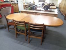 A mid 20th century oval teak extending dining table with five chairs