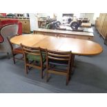 A mid 20th century oval teak extending dining table with five chairs