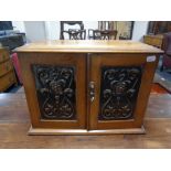 An oak Art Nouveau double door cabinet with inset copper panels,