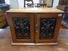 An oak Art Nouveau double door cabinet with inset copper panels,