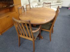 A mid 20th century oval teak G plan extending dining table together with a set of six rail back