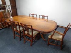 A yew wood twin pedestal dining table with table covers together with a set of six dining chairs in