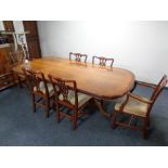 A yew wood twin pedestal dining table with table covers together with a set of six dining chairs in