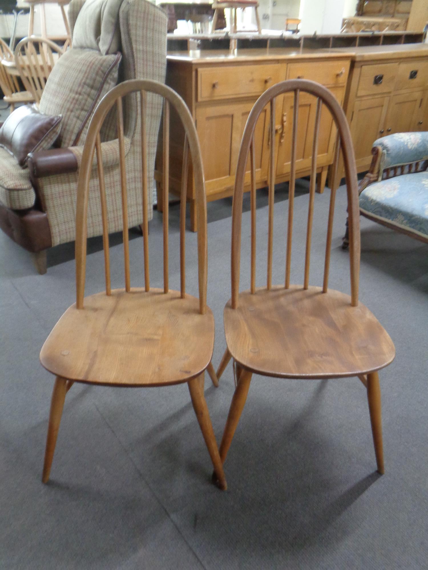 A pair of Ercol solid elm and beech spindle back dining chairs