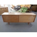 A 20th century Danish sliding door sideboard on raised legs