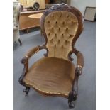 A Victorian mahogany open armchair in a brown buttoned dralon