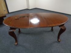 A mahogany oval extending dining table with leaf together with a set of five chairs